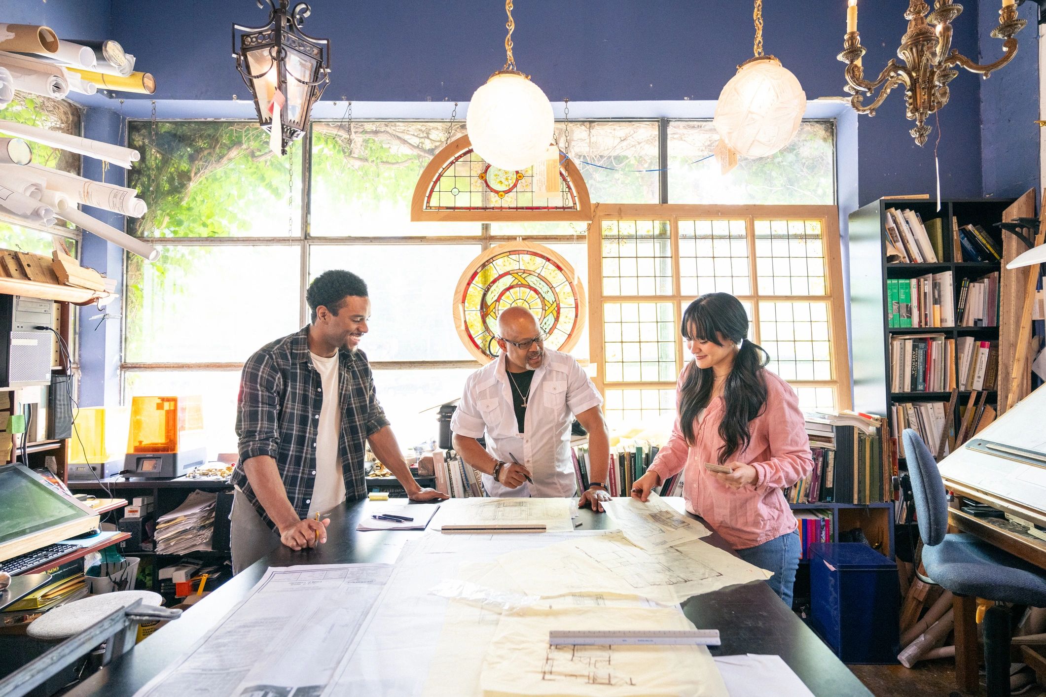 Architecture professionals working on plans in a studio