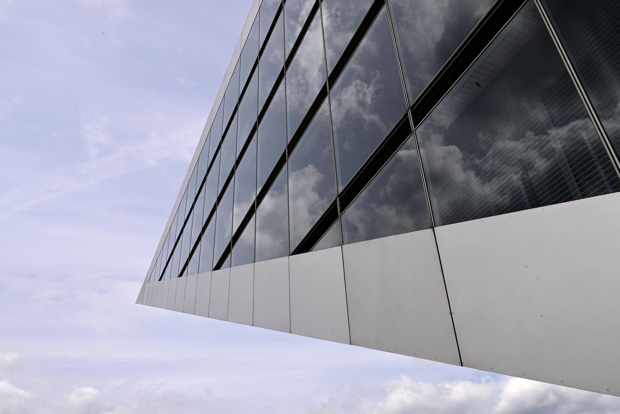 Modern glass building facade reflecting the surrounding urban landscape